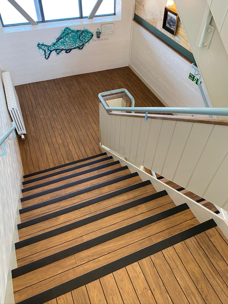 Stairs at Rockfish Brixham installed with Amitico Dry Teak with black feature strip.