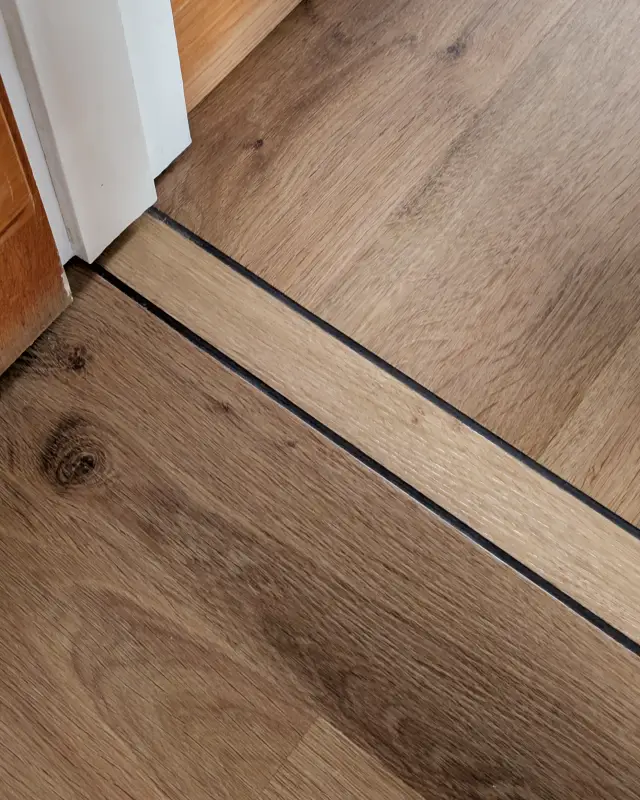 Invictus Wide Plank LVT – Design Strip in Doorway Invictus Wide Plank LVT - Design Strip in Doorway